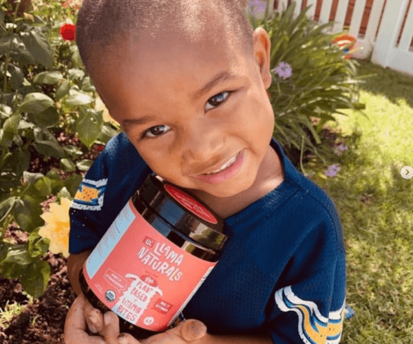 Kid holding Llama Naturals Multivitamin